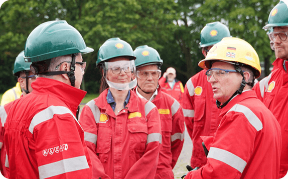 Image shows people with helmets. They wear red clothes